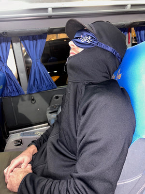 Man sleeping on bus ride overnight between La Paz and Uyuni in Bolivia with eye patch and sweater