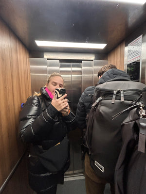 Getting ready to fly from Budapest to Gatwick in London, digital nomad backpackers getaway with backpacks in elevator