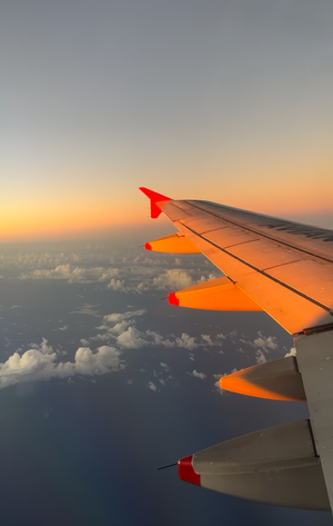 Digital nomads in Costa Rica on their way to Bolivia through Bogota with the sunset over the plane wing.