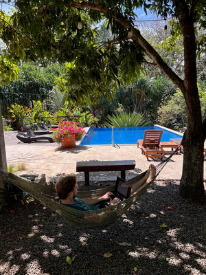 Digital nomads in San Jose Costa Rica working by the pool on their laptop.