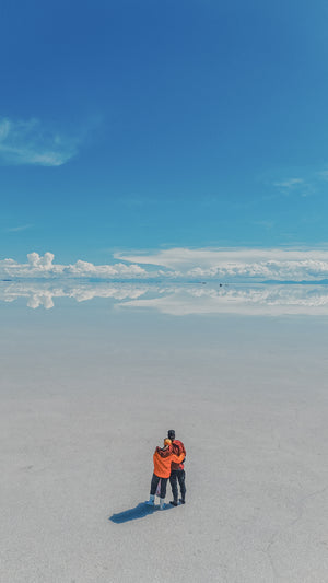 Digital nomad couple looking out to beautiful Salt Flats in Bolivia near Uyuni