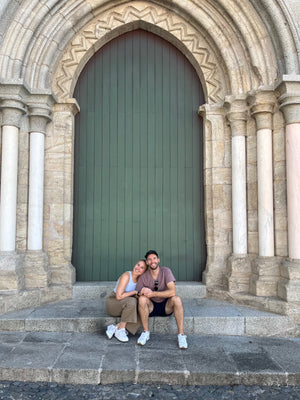 Young couple sitting outside historic building in Evora Portugal at the Chapel of Bones