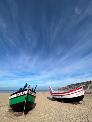 Traditional Portuguese fishing boats displayed on the beach in Nazare Portugal