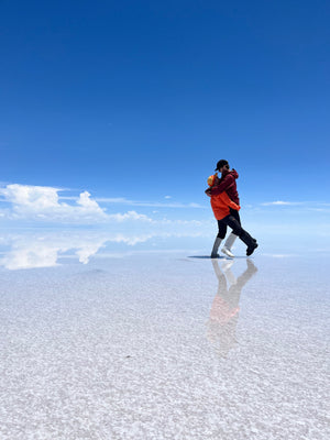 Digital nomads travelling through the Salt Flats in Bolivia near Uyuni. Couple travel, slow travel, working remotely, vegan travel, budget travel. Posing on the Salt Flats.