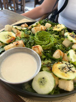 Digital nomads living in Santiago eating vegan plant-based food at Katako restaurant enjoying a fresh salad with crispy tofu, cucumber, lettuce, avocado