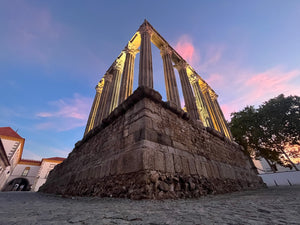 Beautiful and daunting Roman Temple in Evora Portugal UNESCO World Heritage site during sunset with pink clouds